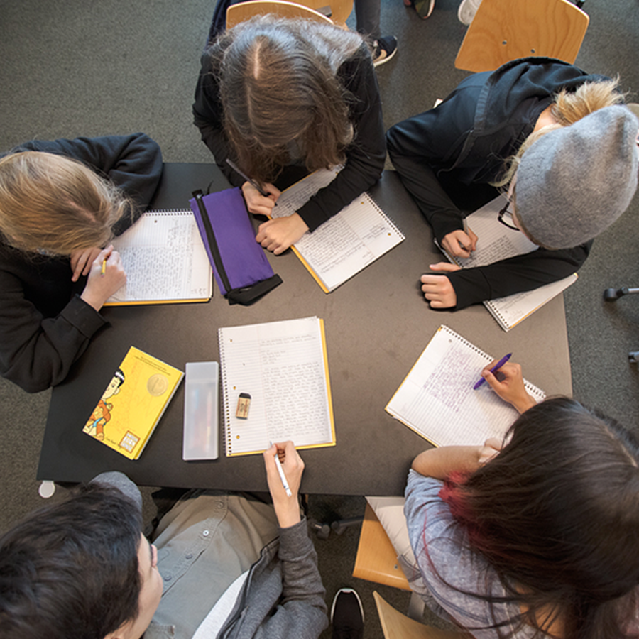 Avenues students from above, writing in notebooks