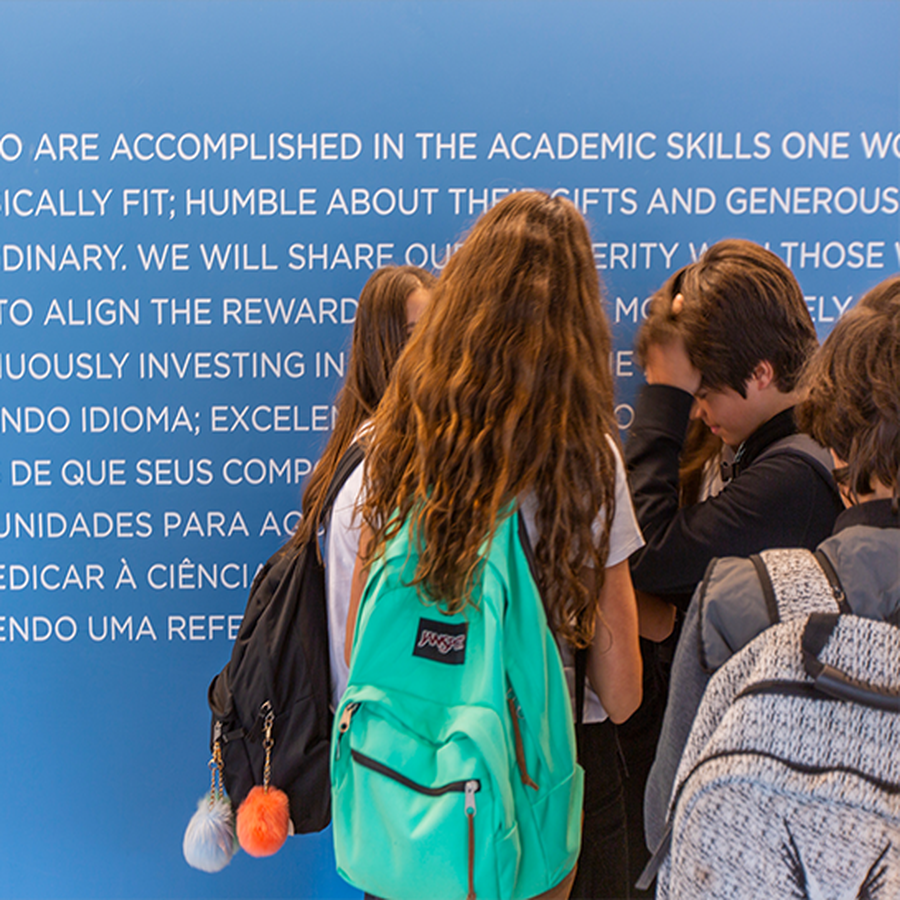 Students in front of a wall with the Avenues mission